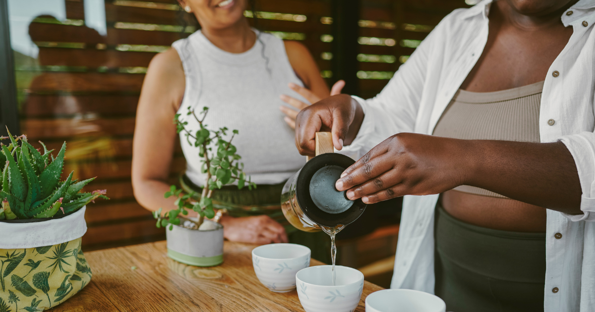 Guests enjoying a herbal tea experience during a wellness retreat at Watermouth Castle, with tea being poured in a calm indoor setting.