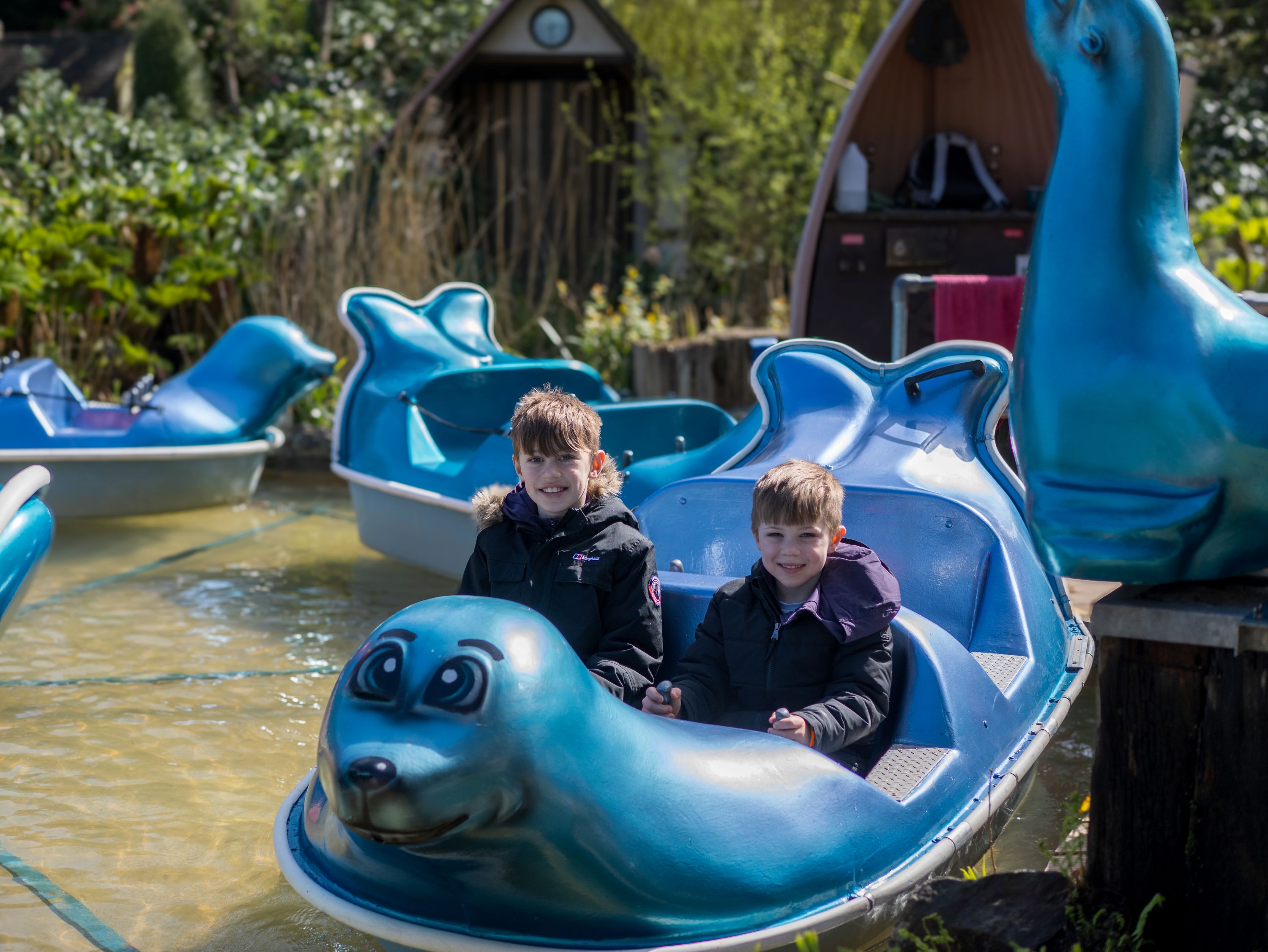 Two children enjoying a boat ride at Watermouth Castle, a family attraction in North Devon
